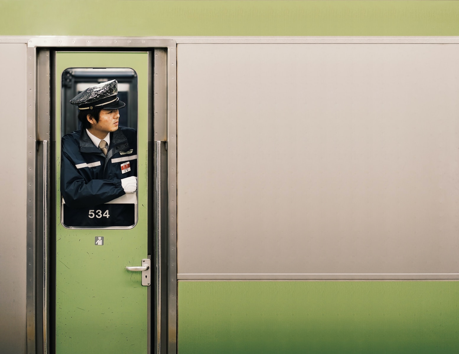 a man in uniform is seen through the door of a train