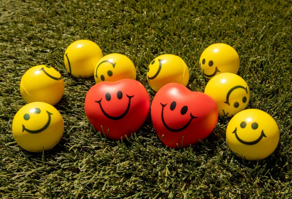 red and yellow smiley emoji on green grass